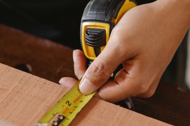 Careful measuring during a carpentry project.